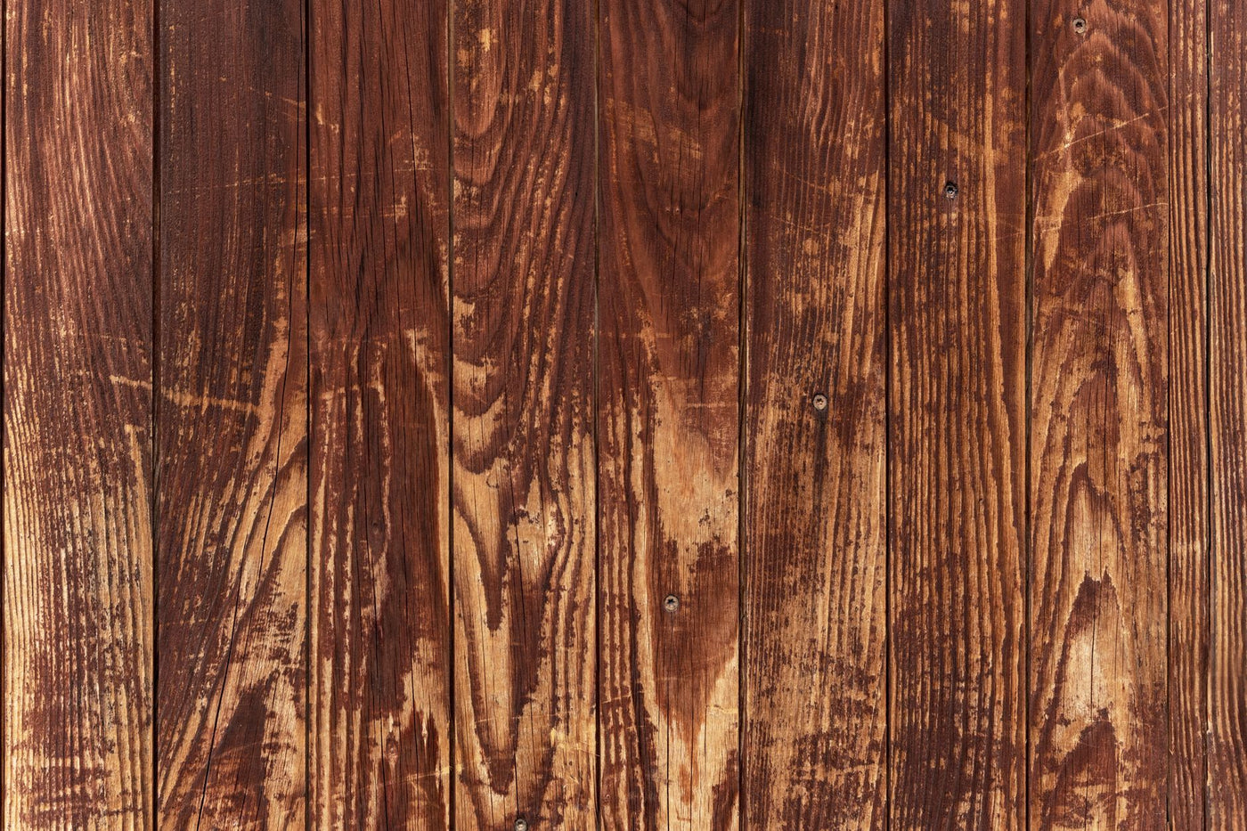 Close-up of vintage wooden planks showing rich brown textures and natural grain patterns.
