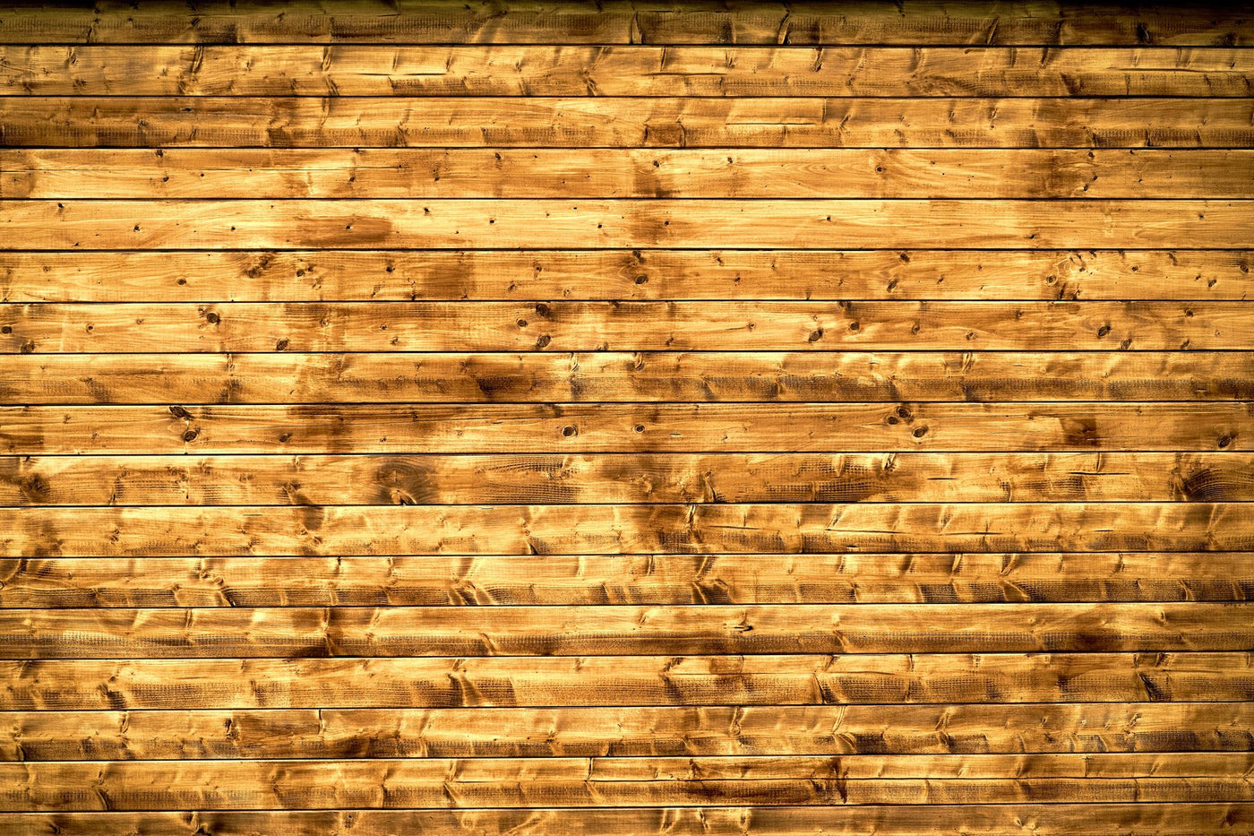 Textured wooden planks forming a rustic wall, perfect for backgrounds or design elements.